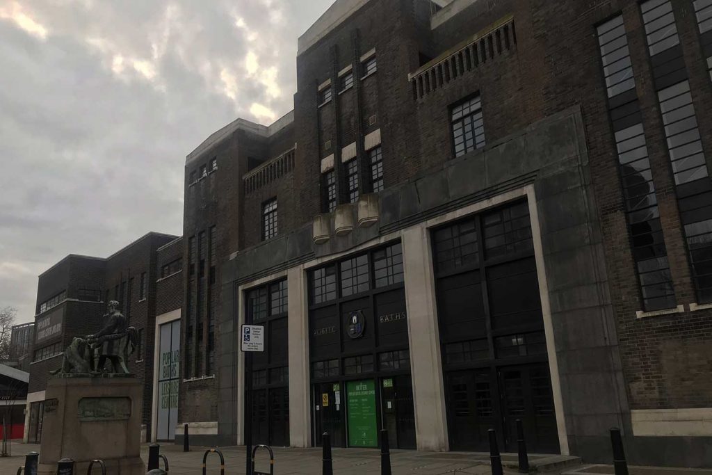 An exterior image of Poplar Baths and leisure centre with the statue of Edward William Wyon with him is his faithful newfoundland dog Hector.