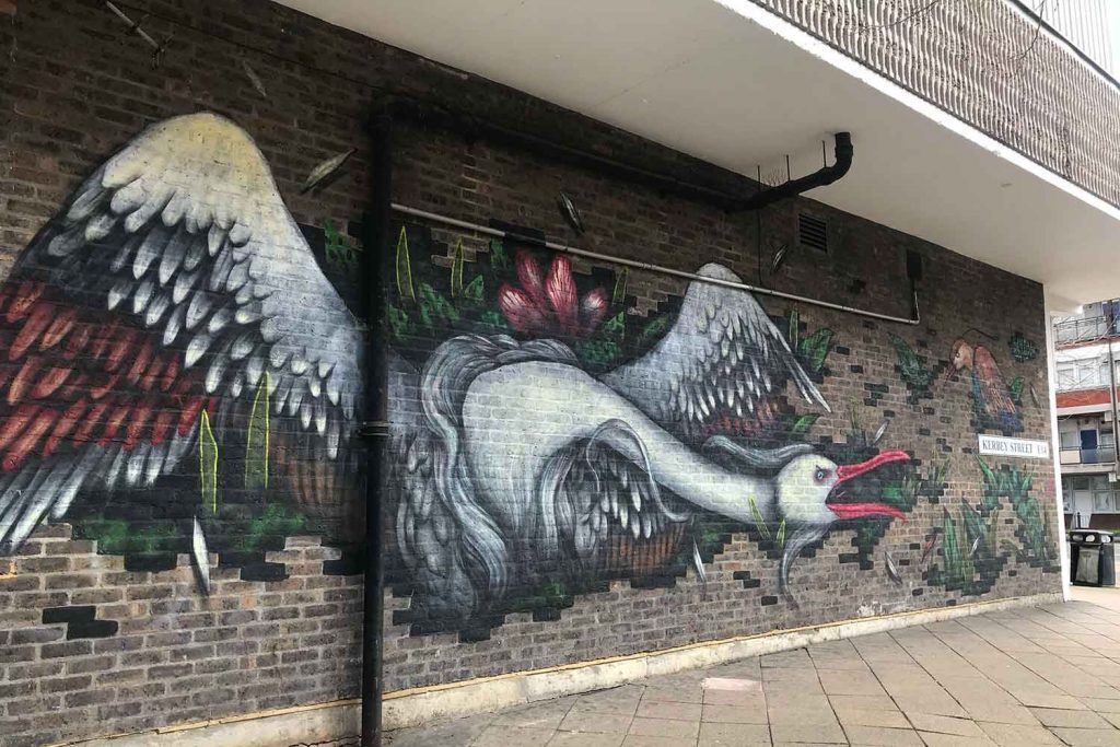 The bird street art is painted on brown bricks of a Barclays Bank on Kerbey Street 