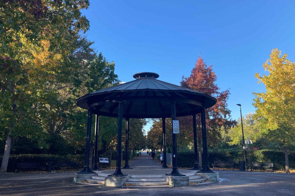 A bandstand surrounded by autumn trees in Ropefields Park. 