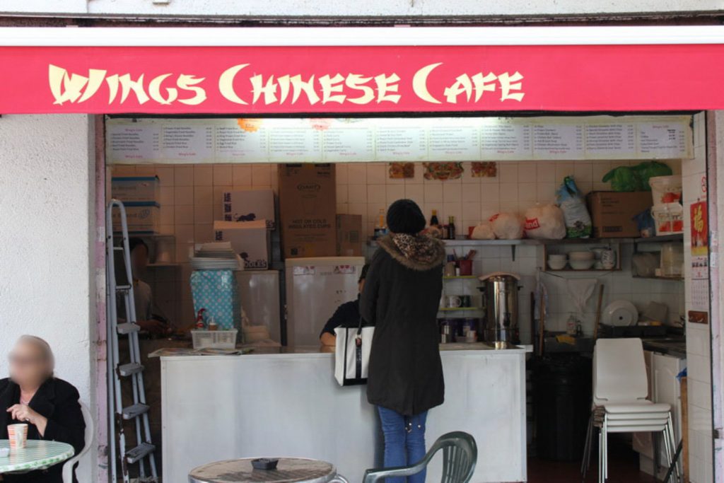 A lady orders food outside Wings Chinese Cafe in Poplar.