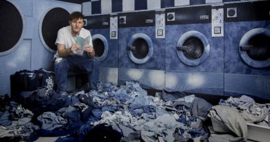 Picture of Ian Berry Reading a book among denim.