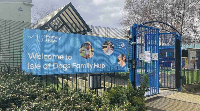 Blue sign at the entrance to a Family Hub Centre on the Isle of Dogs in East London.