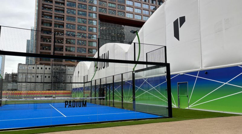 Padium padel court behind glass walls in Canary Wharf, East London.