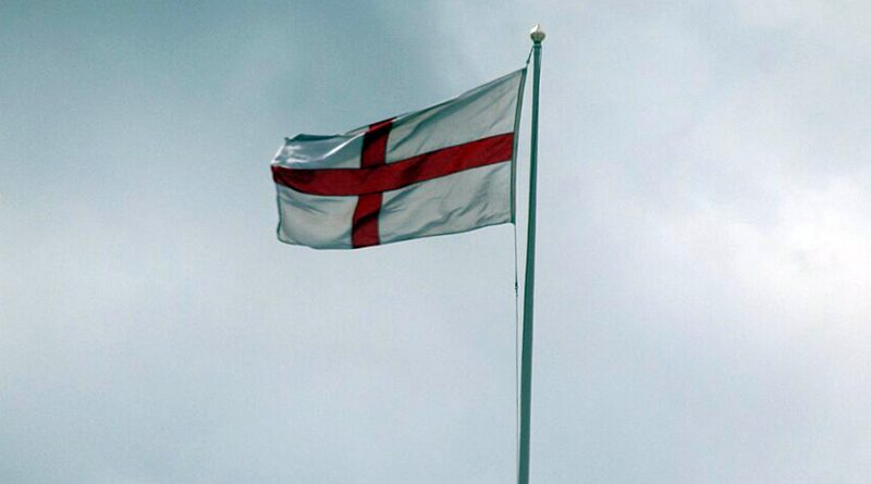 The red and white St. George's Cross flying against a cloudy sky.